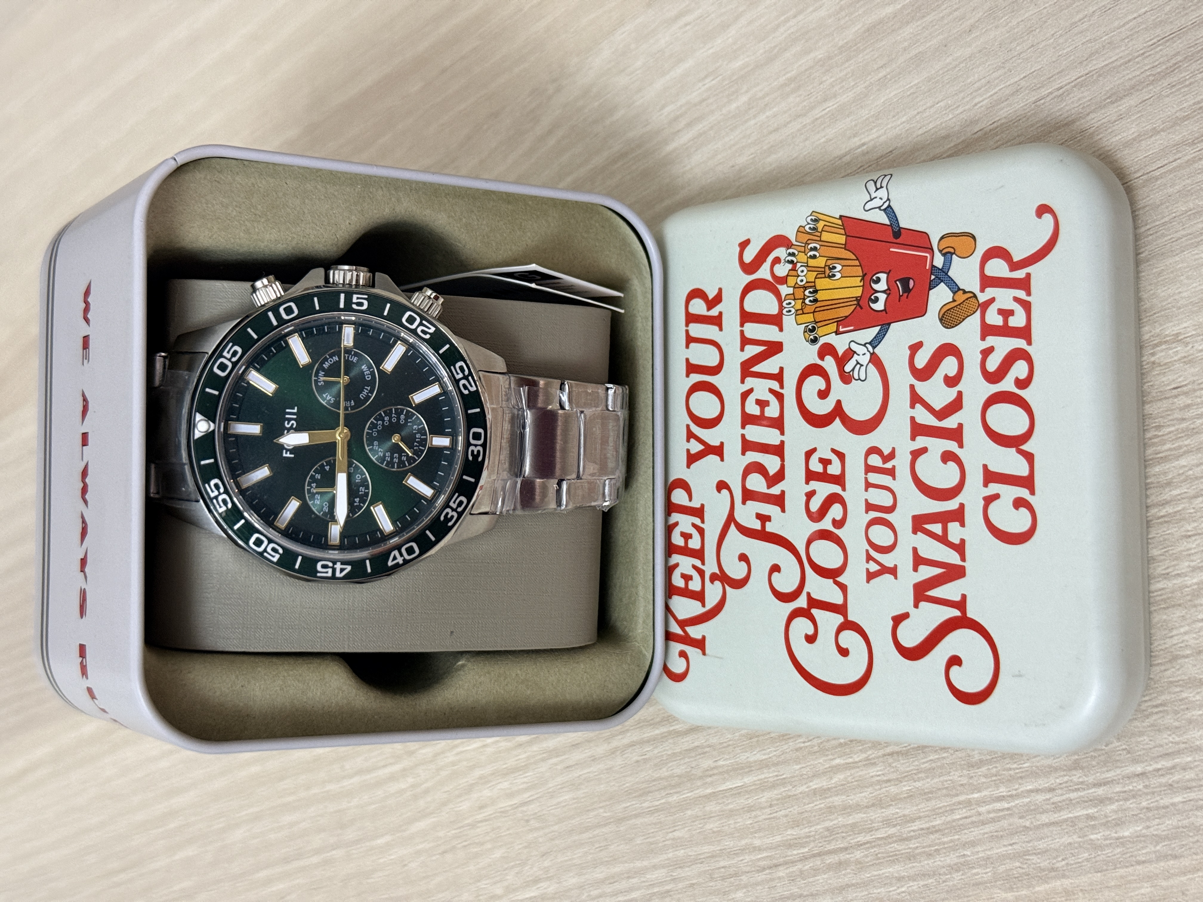 Reloj plateado con esfera verde y fondo verde