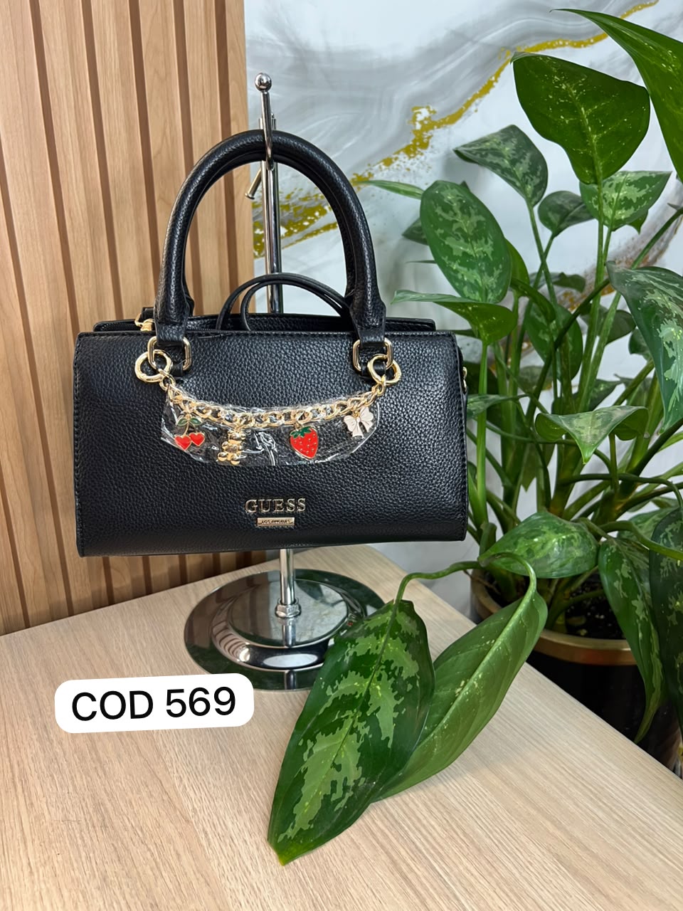 BOLSITO NEGRO GUESS CON CHARMS DORADO RECTANGULAR